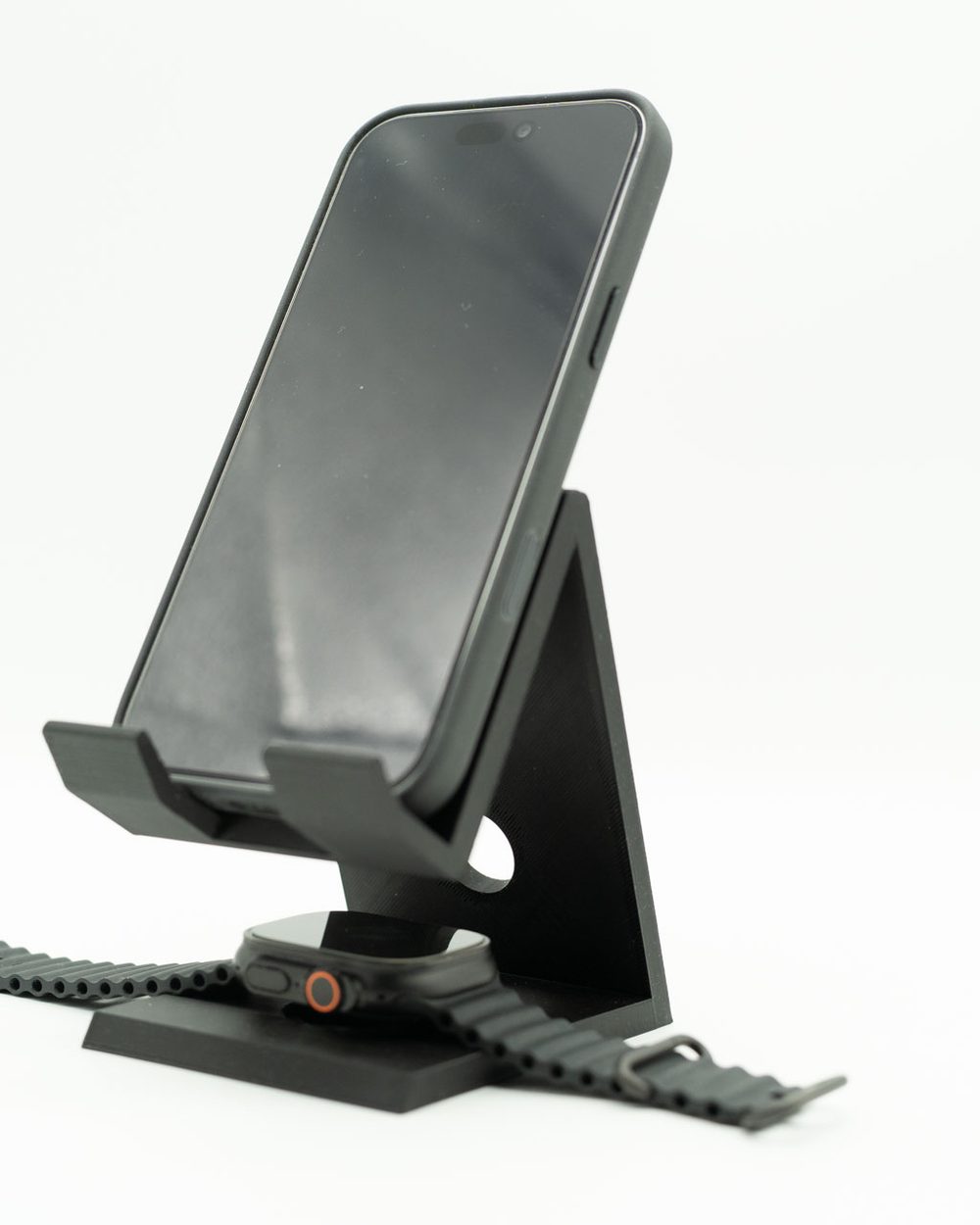 Suporte preto inclinado para iPhone com Apple Watch a carregar na base