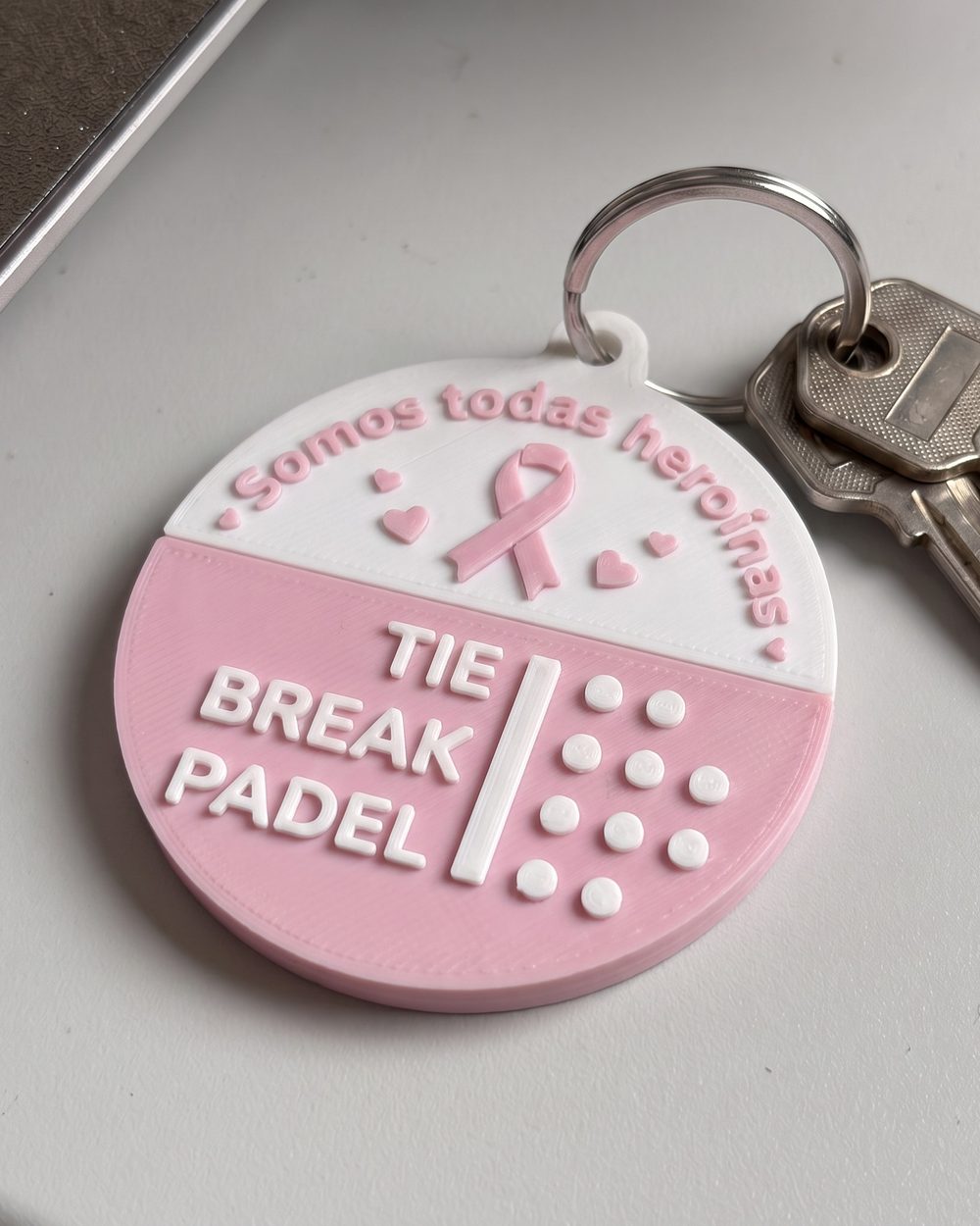 Porta-chaves redondo rosa e branco da campanha Outubro Rosa do Tie Break Padel